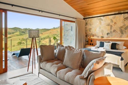 a bedroom with a couch and a bed and a balcony at Casa ALPIN in São José dos Campos