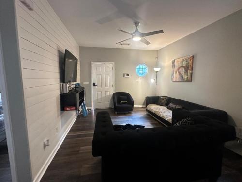 a living room with a couch and a ceiling fan at Basic 4 bedrooms with 6 beds 15 min from downtown sleeps 9 Adults comfortably for Work crews and Large groups in Atlanta
