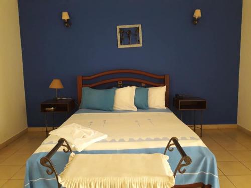 a bedroom with a large bed with a blue wall at Hotel Balneario Las Tinajitas in Choreti
