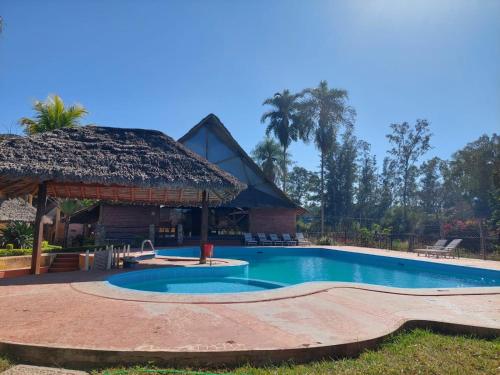 a swimming pool in front of a building at Hotel Balneario Las Tinajitas in Choreti