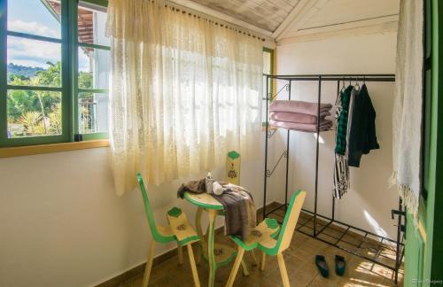 a room with a table and chairs and a window at Pousada da Sirlei in Tiradentes