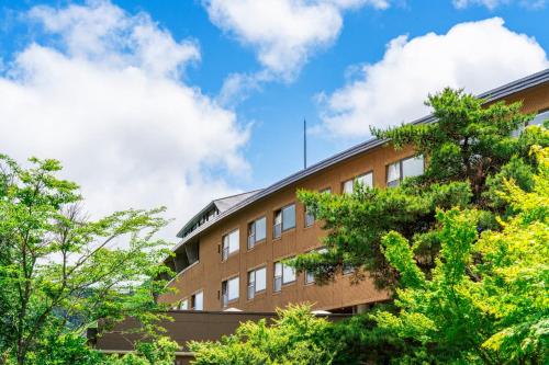 a brick building with trees in front of it at La Vista Minami Aso Grand opening October 2nd 2026 in Minami Aso