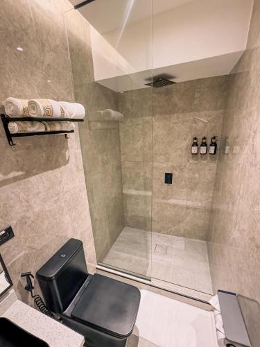 a bathroom with a shower with a black toilet at Hotel Arkam in San Salvador