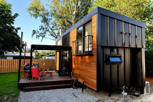 a small house with a deck with a table at Tiny House - Big Luxury in Wanaka