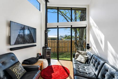 a living room with a couch and a tv at Tiny House - Big Luxury in Wanaka