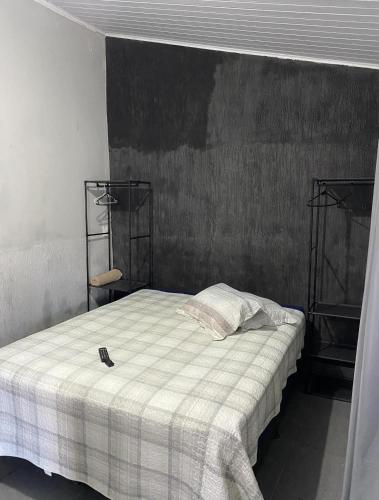 a bedroom with a bed with a checkered blanket at Custo benefício Piri in Pirenópolis