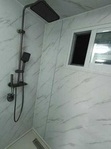 a shower with a window in a bathroom at KF Logement Wallis in Hihifo Airport