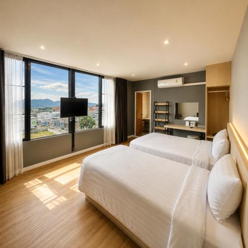 a hotel room with two beds and a large window at V1 boutique hotel in Kanchanaburi City