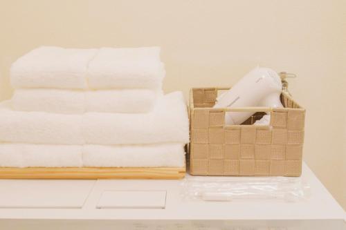 a pile of towels sitting next to a basket of towels at Haul Sakuramachi in Kumamoto