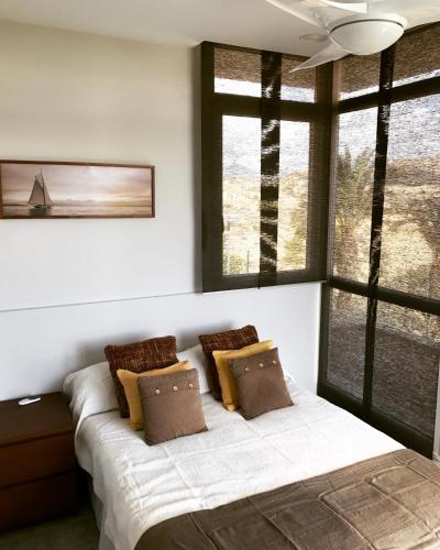 a bedroom with a bed with pillows and a window at 01 Loft Alenda Golf in Monforte del Cid