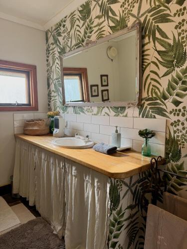 a bathroom with a sink and a mirror at CIRQUE 5 - Alpine Lodge built around a ski lift tower in Merrijig