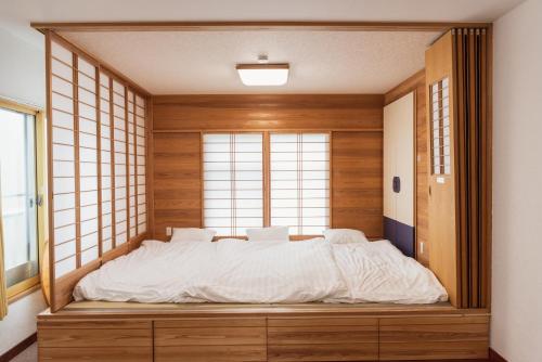 a large bed in a room with a window at 民泊八のや in Hachioji