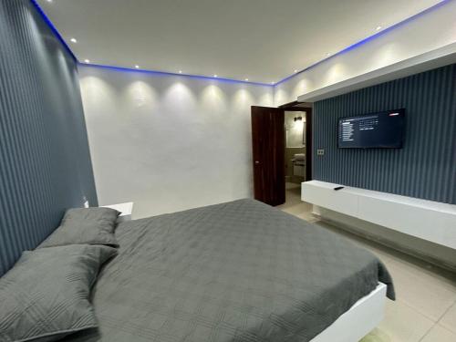 a bedroom with a bed and a tv on the wall at Ts02 torre B in La Romana