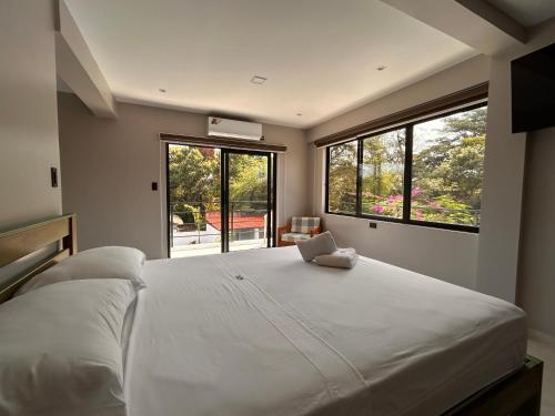 a bedroom with a large white bed with a laptop on it at Torre OCEAN DRIVE in Montañita