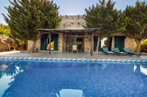 a villa with a swimming pool in front of a house at Sea-Sunset Views Villa Lefkothea with Private Pool near Elafonissi in AmigdhalokeFálion