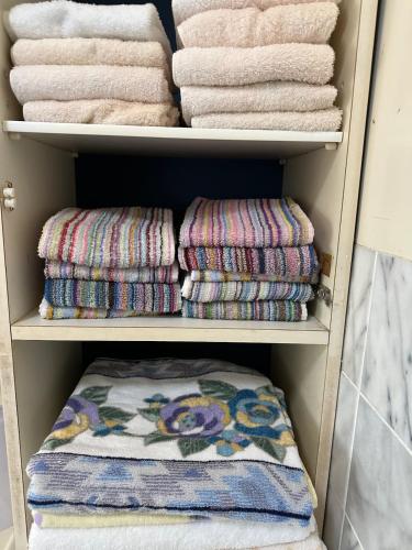 a closet with towels and towels at 空港近くの温泉宿 翻車魚庵 in Kirishima