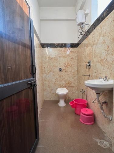 a bathroom with a toilet and a sink at Hotel GMP in Hoshangābād