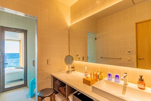 a bathroom with a sink and a mirror at さざね in Kyonan