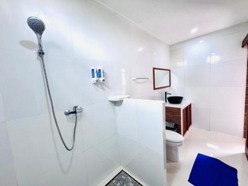 a white bathroom with a shower and a toilet at Dtegal Private Villa in Klungkung