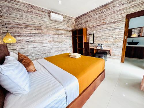 a bedroom with a bed and a wooden wall at Dtegal Private Villa in Klungkung