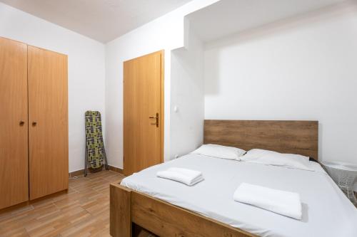 a bedroom with a large white bed and a wooden cabinet at Apartments Dalmatia Blue in Mlini