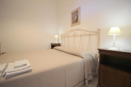 a bedroom with a bed with a lamp and a dresser at Home Holiday Salento Monica's House in Otranto