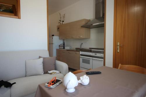 a living room with a table with a couch and a kitchen at Home Holiday Salento Monica's House in Otranto