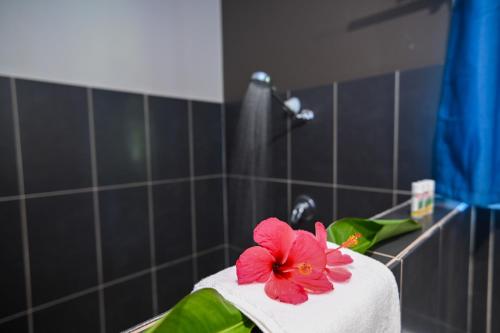 a towel with a flower on top of a bathroom sink at E' Nauwi Beach Resort in Port Vila