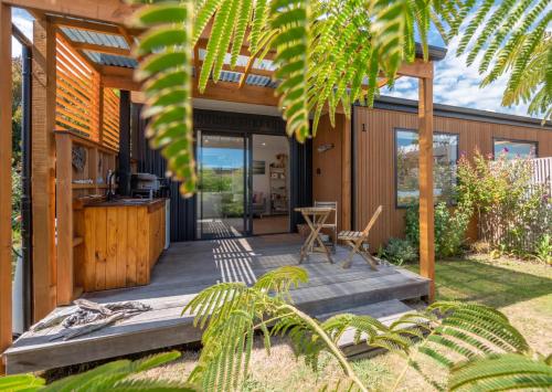 a house with a wooden porch with a table at Studio at Pohara in Pohara