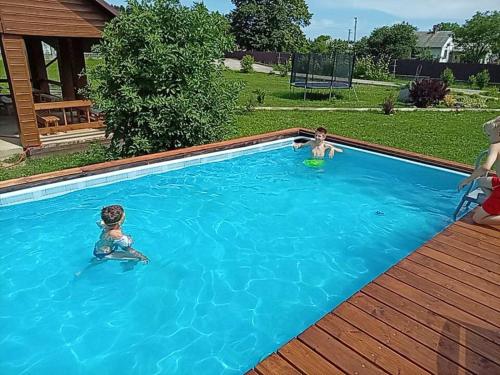 two children are playing in a swimming pool at Садиба Буквиця in Migovo