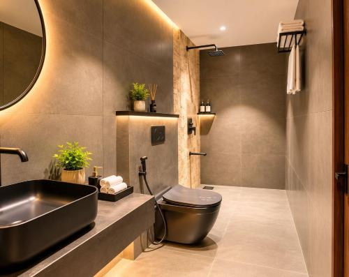 a bathroom with a black toilet and a sink at Hotel Vdara Bliss in Vijayawāda