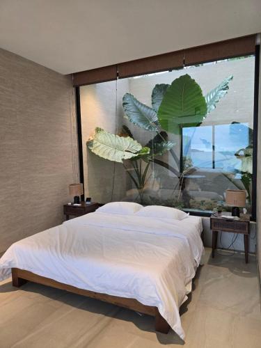 a bedroom with a large bed and a large window at Sabi by the Sea Kep in Kep
