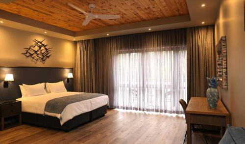 a bedroom with a bed and a large window at Big Blue Sodwana Bay in Sodwana Bay