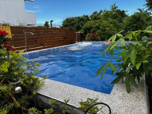 a swimming pool with blue water in a garden at 寧靜の家A區14人Villa專暑獨棟隱私無憂 in Hengchun South Gate