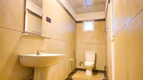 a small bathroom with a toilet and a sink at Surf and stay in Weligama