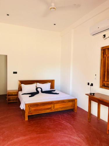 a bedroom with a large bed with a wooden frame at Azura Hotel in Pottuvil