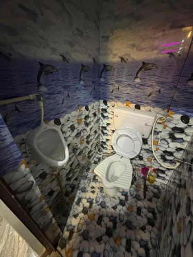 a bathroom with two toilets and a urinal and a sink at Dixit's Villa in Kānpur