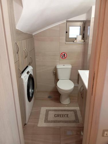 a small bathroom with a toilet and a sink at Tigani House in Tyros