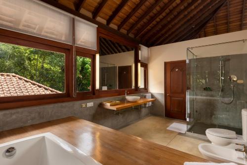 a bathroom with a tub and two sinks and a shower at Kandy Knightsdale Villa in Panwila