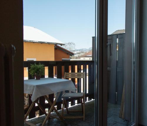 a table and chairs on a balcony with a window at Hotel Kreuzwirt in Engerwitzdorf