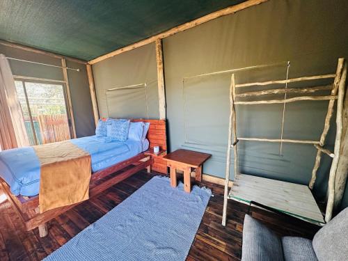 a bedroom with a bed and a chair in it at Nyati House in Khwai