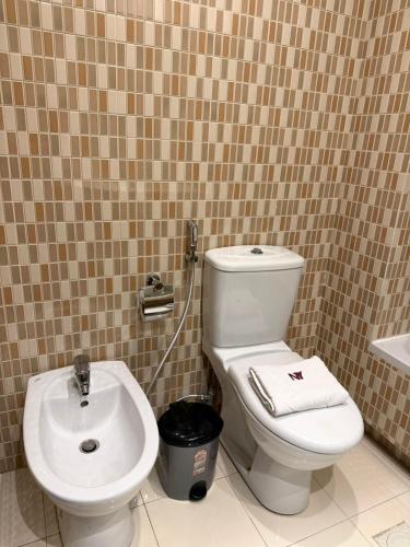 a bathroom with a toilet and a sink at Ny Suites in Beirut