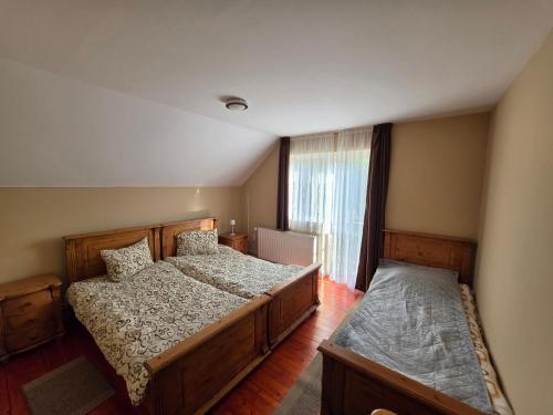 a bedroom with two beds and a window at Silentium Clavem Domus III. in Odorheiu Secuiesc