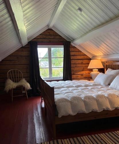 a bedroom with a large bed in a room with a window at Reine Harbour Cabins in Moskenes