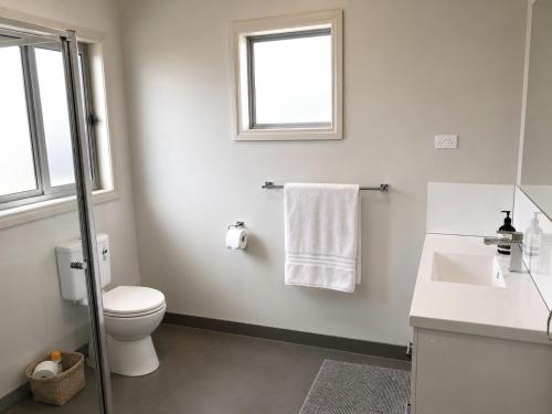 a bathroom with a toilet and a sink and a window at Bellarine Breeze in Drysdale