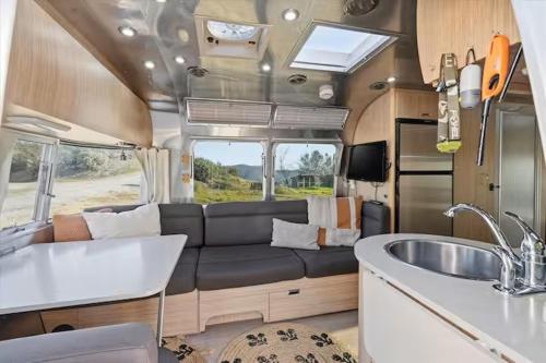 a living room and kitchen in an rv at Yosemite's Best Glamping Airstream Experience! in Coarsegold