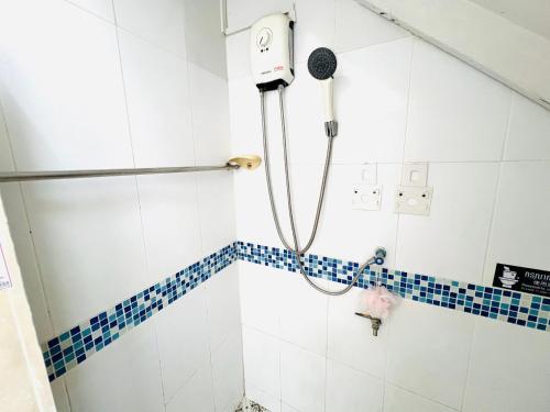 a shower in a bathroom with a blue and white tiles at Pineapple Express hostel at BKK in Bang Bua Thong Railway Station