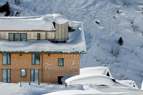 a hotel in the snow with a sign on it at Ski Hotel Mondschein 1739 in Stuben am Arlberg
