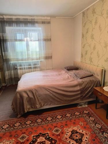 a bedroom with a bed and a window and a rug at Avaxil Pirqulu in Avaxıl