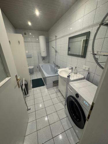 a bathroom with a sink and a washing machine at Park apartman Kertes ház Murau központjában gyönyörű kilátással Dog friendly garden house with a wonderful view in Murau centre in Murau
